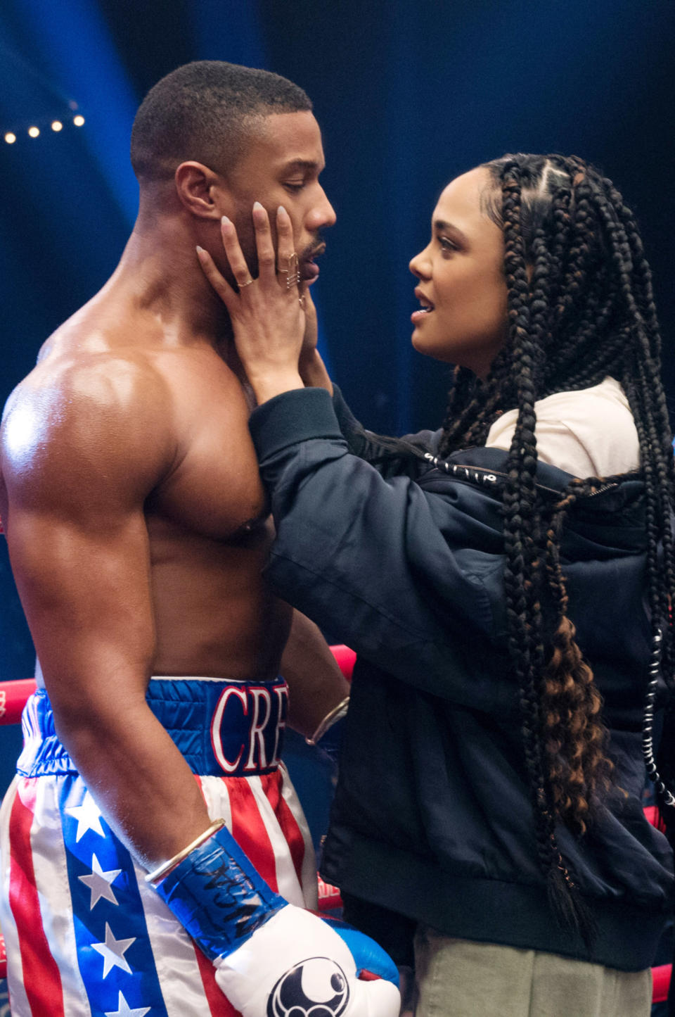 Tessa holding Michael's face as she talks to him inside a boxing ring in a scene from Creed