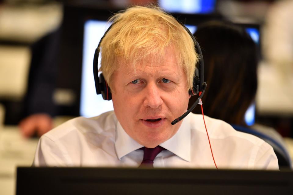 Britain's Prime Minister Boris Johnson speaks to a caller as he mans the phones at the Conservative Campaign Headquarters Call Centre in central London on December 8, 2019. - Britain will go to the polls on December 12, 2019 to vote in a pre-Christmas general election. (Photo by Ben STANSALL / POOL / AFP) (Photo by BEN STANSALL/POOL/AFP via Getty Images)