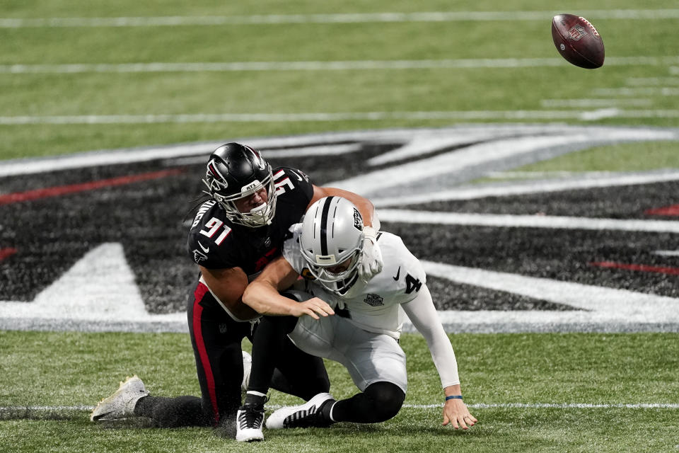 Atlanta Falcons defensive tackle Jacob Tuioti-Mariner (91) hits Las Vegas Raiders quarterback Derek Carr (4) for a fumble during the first half of an NFL football game, Sunday, Nov. 29, 2020, in Atlanta. The Atlanta Falcons recovered the ball. (AP Photo/John Bazemore)