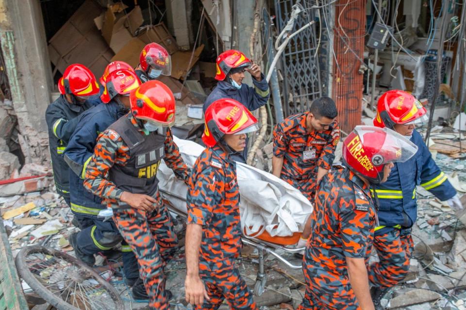 Firefighters shift a body bag of victims after an explosion at Siddique Bazar area in Dhaka, Bangladesh on 7 March (EPA)