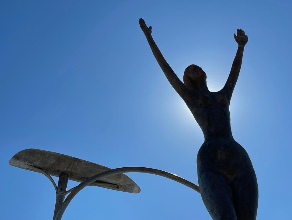 Here, one of Three Graces sculptures made of gold anodized aluminum at the intersection of Ortiz Boulevard and U.S. 41, the entrance to Warm Mineral Springs Park in North Port, is silhouetted by the Sun.