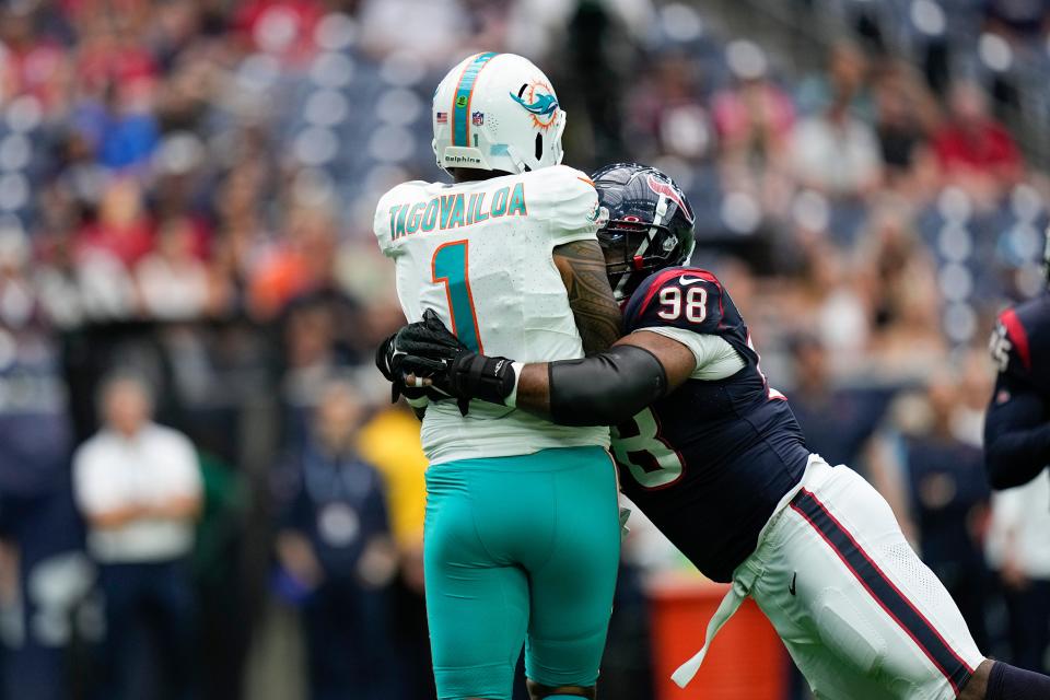 Houston Texans defensive tackle Sheldon Rankins (98) makes a hit on Miami Dolphins quarterback Tua Tagovailoa (1) as he attempts a pass during the first half of an NFL preseason football game, Saturday, Aug. 19, 2023, in Houston. (AP Photo/Eric Gay)
