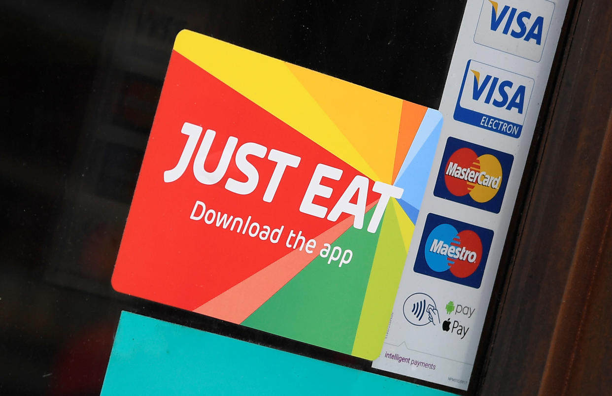 Signage for Just Eat is seen on the window of a restaurant in London, Britain, August 5, 2019. REUTERS/Toby Melville.