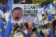 Anti-Brexit demonstrators carry placards and EU flags in London, Saturday, Oct. 19, 2019. In their first weekend session in 37 years, British lawmakers in Parliament debated whether to accept Prime Minister Boris Johnson's proposed new divorce deal with the European Union. (AP Photo/Kirsty Wigglesworth)