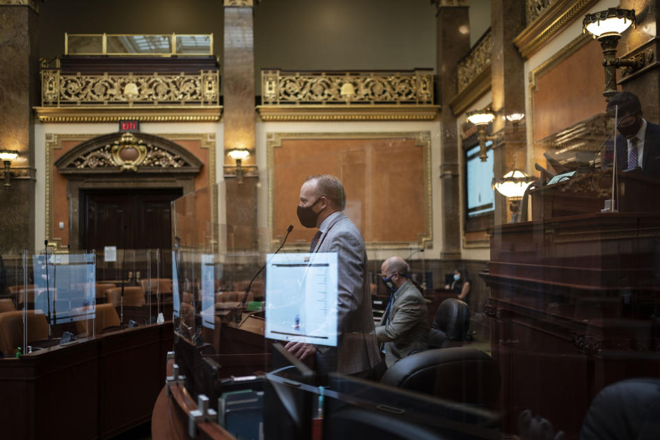 Surrounded by coronavirus barriers, staff members test the sound system of the House chamber of the Utah State Capitol in Salt Lake City. Tuesday, Nov. 17, 2020. When it comes to politics, Utah has long claimed things are different here. Political viciousness is for other places, many politicians will tell you. Legislators are more polite, more willing to compromise. The deep conservativism, the folklore says, includes a powerful strain of compassion. (AP Photo/Wong Maye-E)