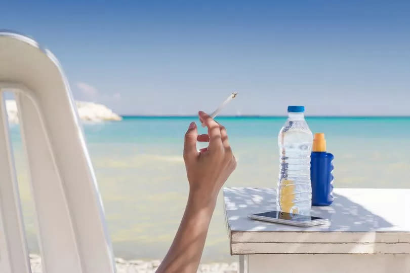 Woman smoking at the beach