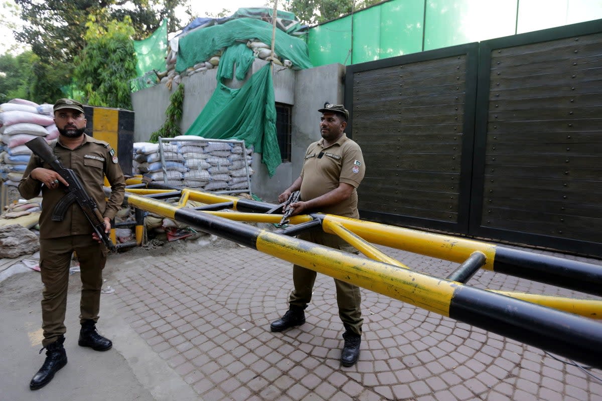 Pakistani security officials stand guard as Lahore Commissioner Muhammad Ali Randhawa searches the residence of former Pakistani Prime Minister Imran Khan at Zaman Park on 19 May (EPA)