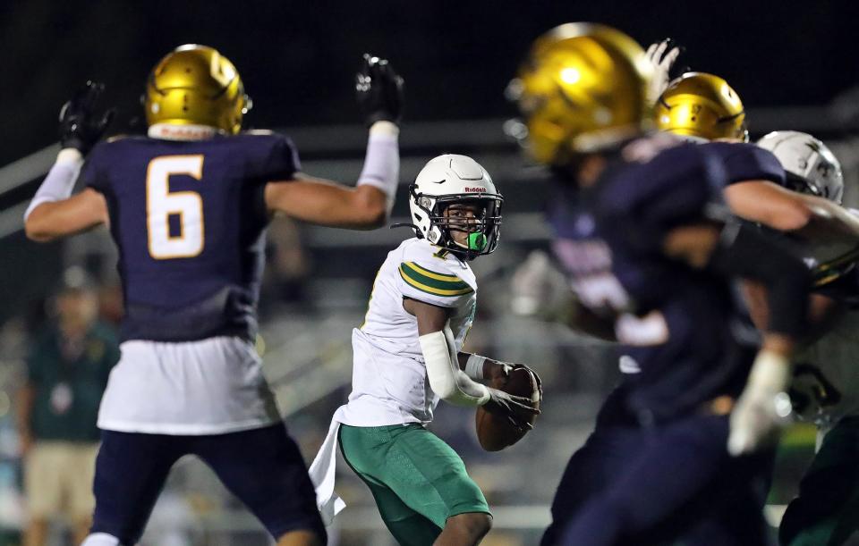 Firestone quarterback Daylyn Taylor, center, searches for a receiver against the Copley Indians during the second half of a high school football game, Friday, Aug. 26, 2022, in Copley, Ohio.