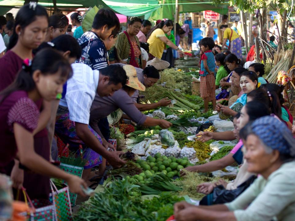 Customers (left) buy vegetables from sellers (right) at a local bazaar near Innlay Lake Friday, May 3, 2019, in southern Shan State, Myanmar.