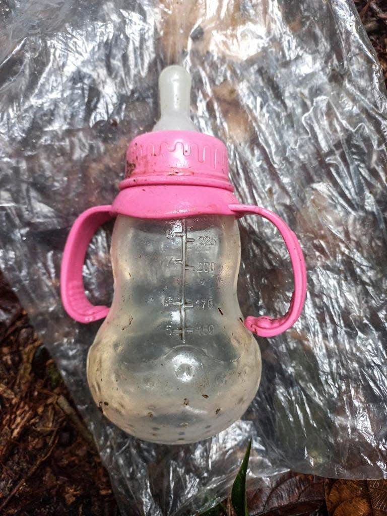 A handout picture released by the Colombian army shows a feeding bottle found in the forest in a rural area of the municipality of Solano, department of Caqueta, Colombia, on May 17, 2023. More than 100 soldiers with sniffer dogs are following the "trail" of four missing children in the Colombian Amazon after a small plane crash that killed three adults, the military said Wednesday.