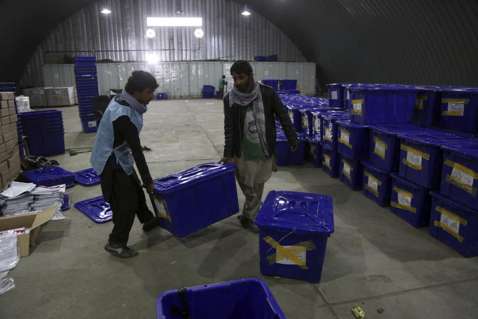 In this Wednesday, Oct. 17, 2018 photo, workers carry ballot boxes for distribution ahead of the parliamentary elections scheduled for Saturday, at the Independent Election Commission compound in Kabul, Afghanistan. Afghans will go to the polls on Saturday, hoping to bring change to a corrupt government that has lost nearly half the country to the Taliban. The Taliban warned students and teachers not to vote and not to allow their schools to be used as polling stations. (AP Photo/Rahmat Gul)