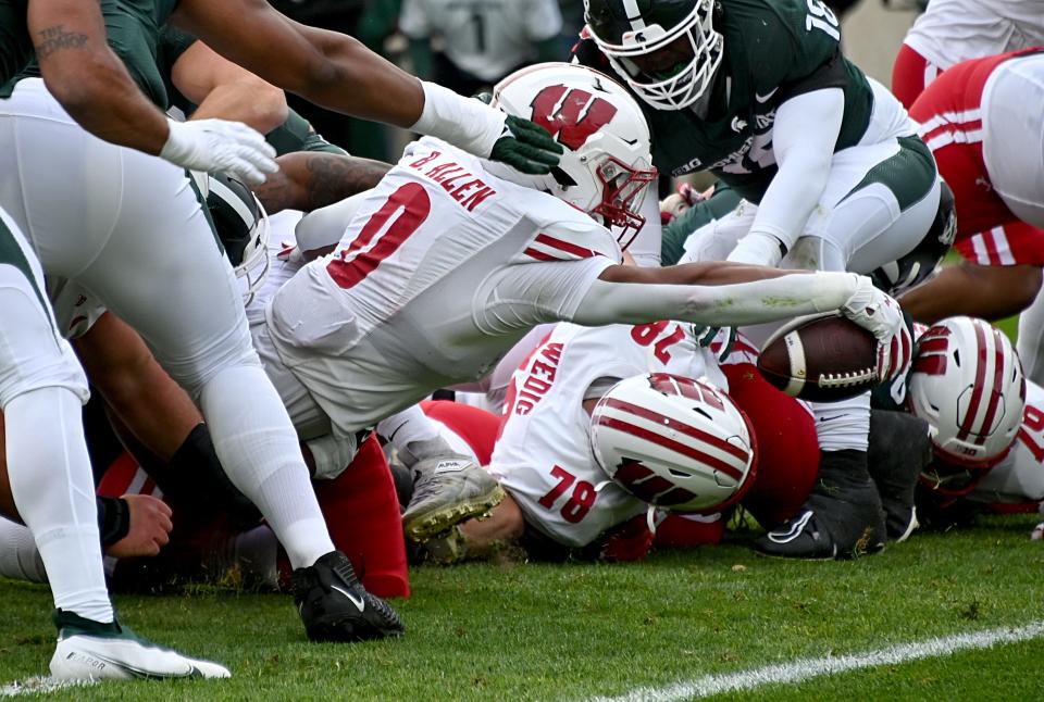 Wisconsin Badgers running back Braelon Allen (0) reaches for the goal line against the Michigan State Spartans on Saturday, Oct. 15, 2022, at Spartan Stadium. Allen scored two 1-yard touchdown runs in the first half.