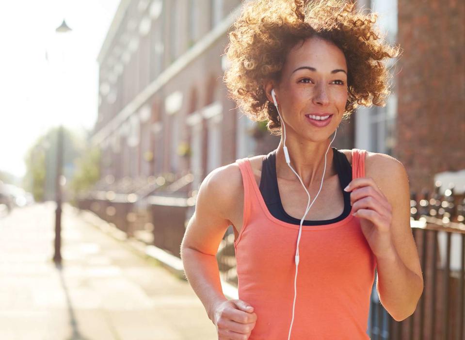 A woman is jogging in the morning in a city.