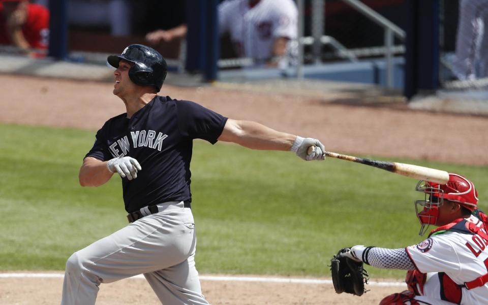 New York Yankees' Matt Holliday (17) follows through on a two-run homer as Washington Nationals catcher Jose Lobaton (59) looks on in fifth inning of a spring training baseball game Monday, March 20, 2017, in West Palm Beach, Fla. (AP Photo/John Bazemore)