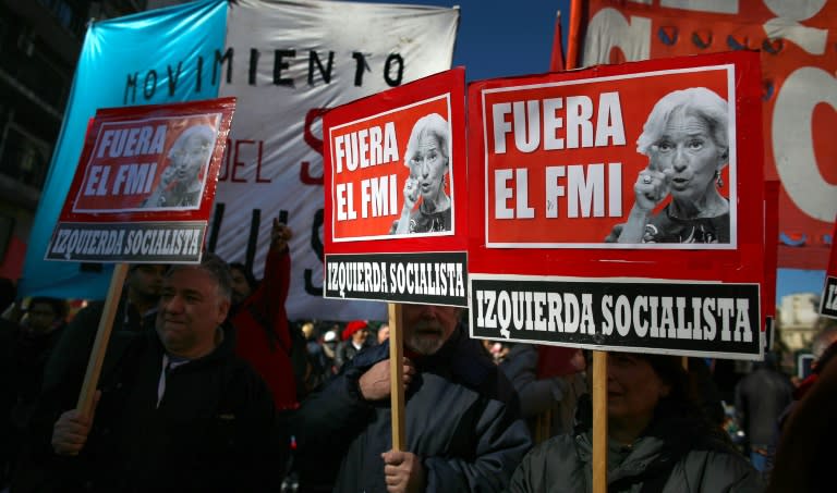 Demonstrators in Buenos Aires hold placards reading "IMF Out" during a protest against Argentina's latest agreement with the International Monetary Fund