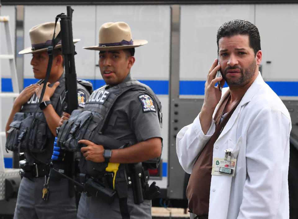 <p>A hospital staff member talks on his phone as he walks past police outside the Bronx-Lebanon Hospital as they respond to an active shooter north of Manhattan in New York on June 30, 2017. (Timothy A. Clary/AFP/Getty Images) </p>