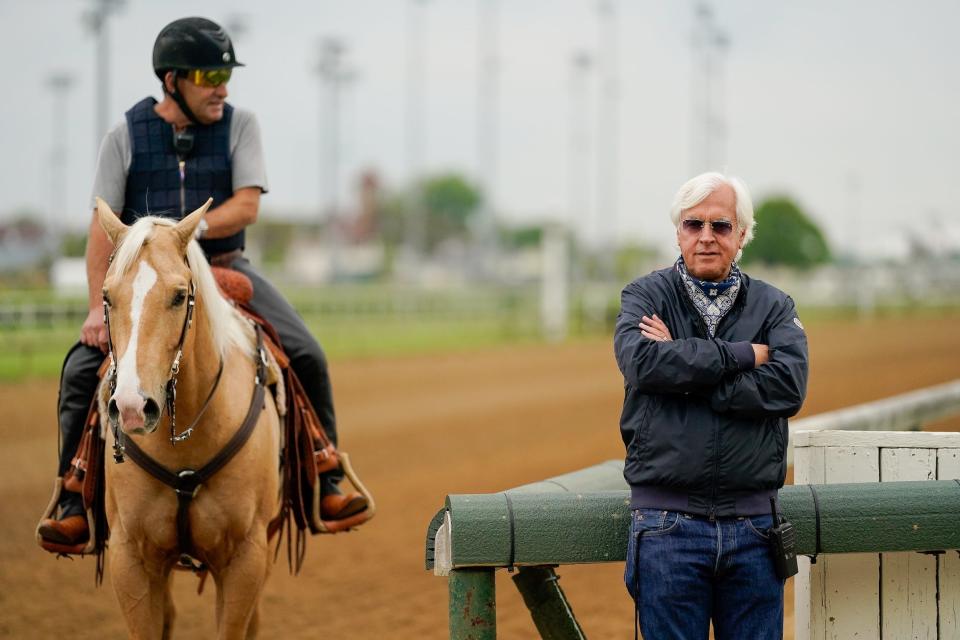 Bob Baffert (right) looks on during training at Churchill Downs.