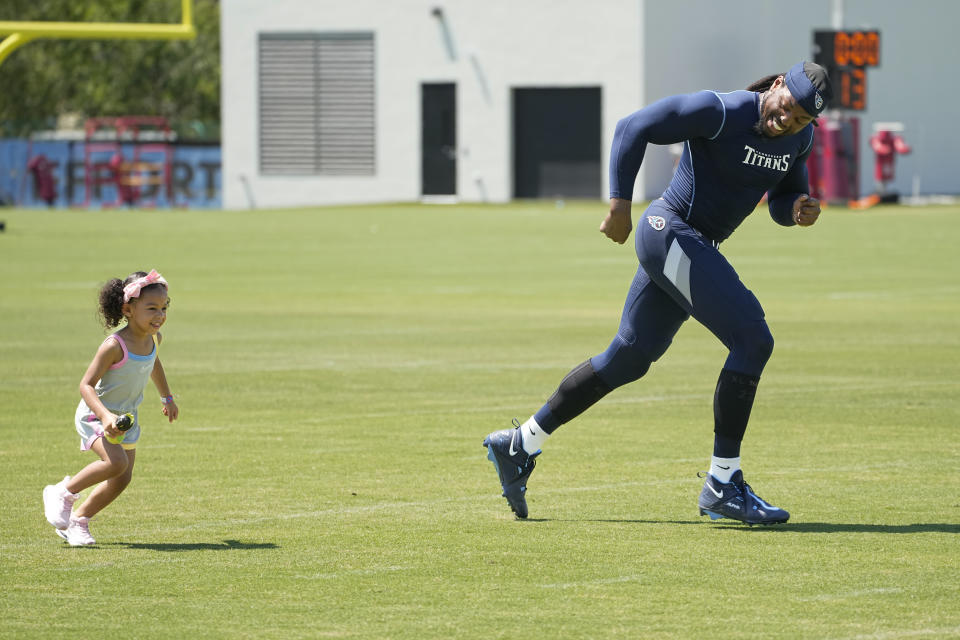 Tennessee Titans running back Derrick Henry, right, runs with his daughter Valentina after an NFL football training camp practice Monday, July 31, 2023, in Nashville, Tenn. (AP Photo/George Walker IV)