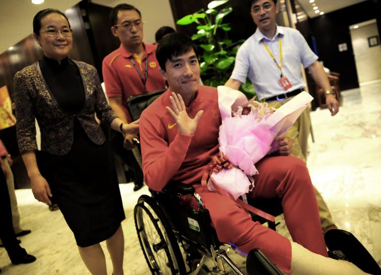 Chinese hurdler Liu Xiang waves as he arrives back in Shanghai on August 14, 2012, after undergoing the knife in London. Liu's coach said he would make a "full recovery" from his ruptured Achilles tendon, but would probably not be in action this year