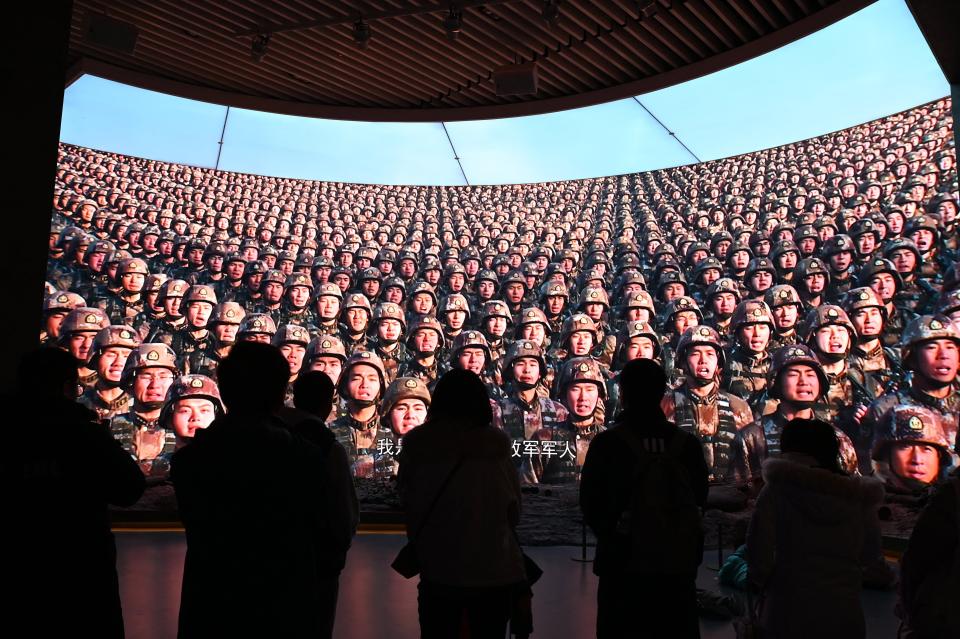 People watch a video about China's military advancements at the Military Museum in Beijing on March 3, 2024.