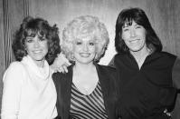 FILE - Jane Fonda, from left, Dolly Parton and Lily Tomlin get together Dec. 12, 1980 at a Los Angeles news conference to promote their movie "9 To 5". Parton's 1980's hit song "9 to 5" has been flipped by Squarespace, the company that helps users build and host their own websites, for a Super Bowl commercial debuting Tuesday, Feb. 2, 2021. Oscar winner Damien Chazelle of "La La Land" fame directed the spot. (AP Photo/Wally Fong, File)