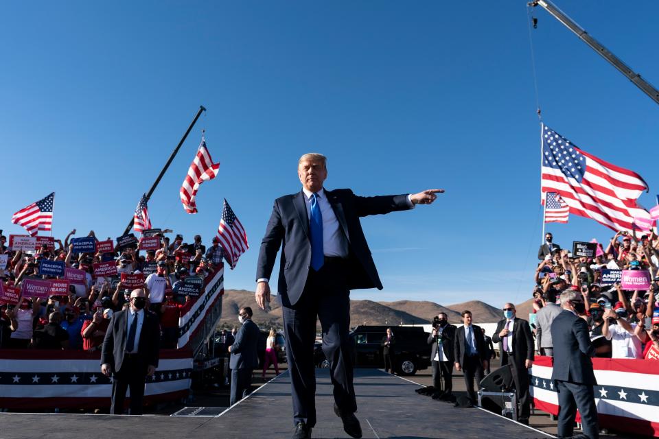 President Donald Trump points to supporters as he arrives to speak at a campaign rally at Carson City Airport, Sunday, Oct. 18, 2020, in Carson City, Nev. (AP Photo/Alex Brandon) ORG XMIT: NVAB129
