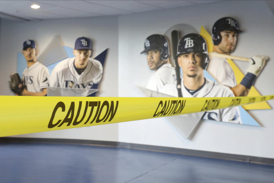 Caution tape closes off parts of Tropicana Field, home of the Tampa Bay Rays, during practice Sunday July 5, 2020, in St. Petersburg, Fla. (AP Photo/Mike Carlson)