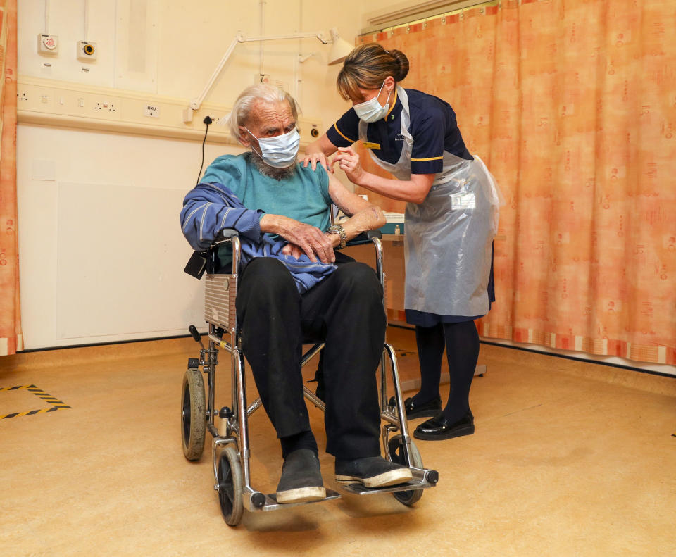 OXFORD, ENGLAND - JANUARY 04 88-year-old Trevor Cowlett receives the Oxford University/AstraZeneca COVID-19 vaccine from nurse Sam Foster at the Churchill Hospital in Oxford as the NHS increases its vaccination programme with 530,000 doses of the newly approved jab available for rollout across the UK on January 4, 2021 in Oxford, England.  (Photo by Steve Parsons - WPA Pool/Getty Images)