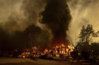 Flames consume a house near Old Oregon Trail as the Fawn Fire burns north of Redding in Shasta County, Calif., on Thursday, Sept. 23, 2021. (AP Photo/Ethan Swope)
