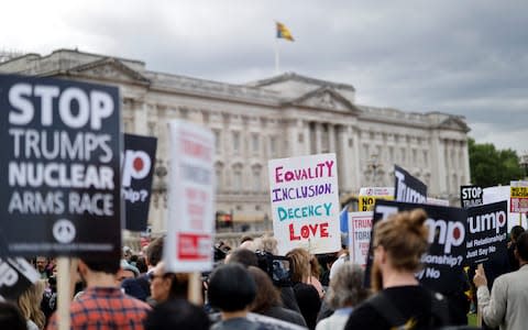 Anti-Trump demonstrators hold placards as they protest outside of Buckingham Palace - Credit: Tolga Akmen / AFP