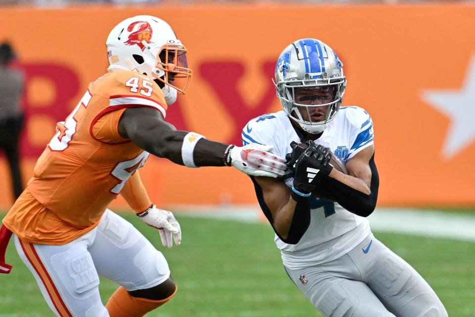 Detroit Lions wide receiver Amon-Ra St. Brown (14) tries to evade Tampa Bay Buccaneers linebacker Devin White (45) after a catch during the first half of an NFL football game Sunday, Oct. 15, 2023, in Tampa, Fla. (AP Photo/Jason Behnken)