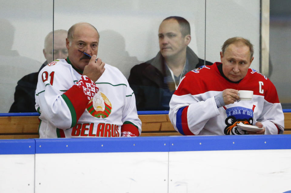 Russian President Vladimir Putin, right, and Belarusian President Alexander Lukashenko take a break during a match of the Night Hockey League teams in Rosa Khutor in the Black Sea resort of in Sochi, Russia, Friday, Feb. 7, 2020. Russian President Vladimir Putin is hosting the leader of Belarus for another round of talks on closer integration amid mounting Russian economic pressure on its ex-Soviet ally. (AP Photo/Alexander Zemlianichenko, Pool)