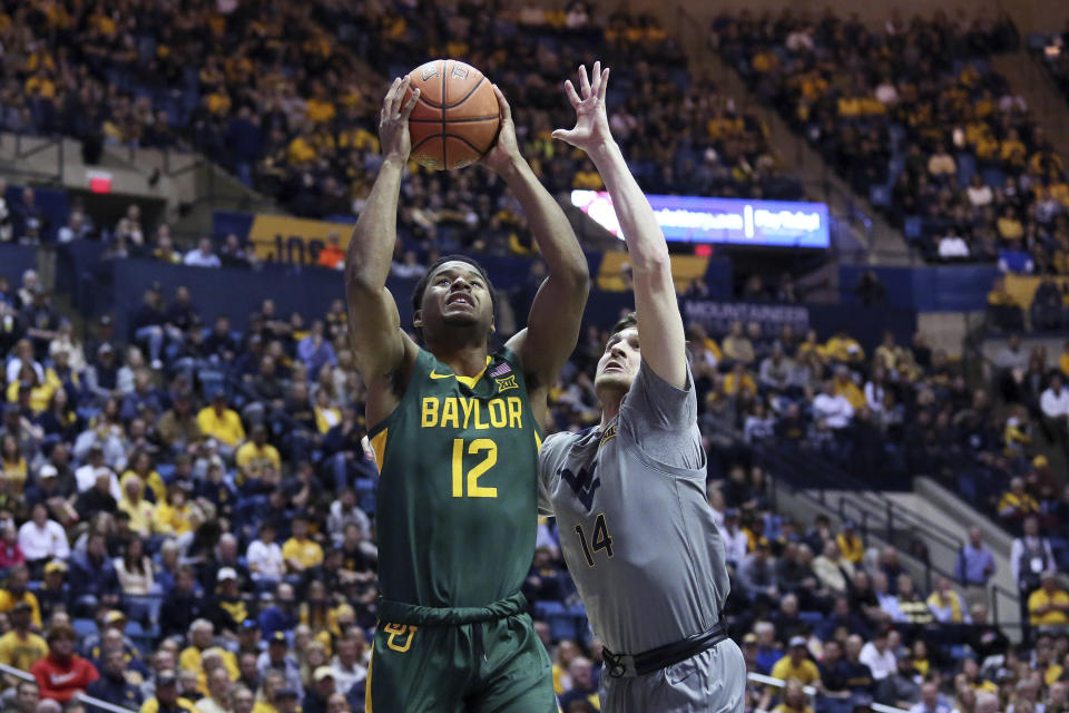 Baylor guard Jared Butler (12) shoots ahead of West Virginia guard Chase Harler (14) during the first half of an NCAA college basketball game Saturday, March 7, 2020, in Morgantown, W.Va. (AP Photo/Kathleen Batten)
