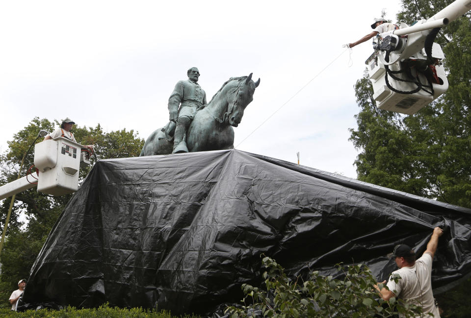 City workers drape a tarp over the statue of Confederate General Robert E. Lee in Charlottesville, Va., on Aug. 23 to symbolize the city’s mourning for Heather Heyer, killed while protesting a white nationalist rally. (Photo: Steve Helber/AP)