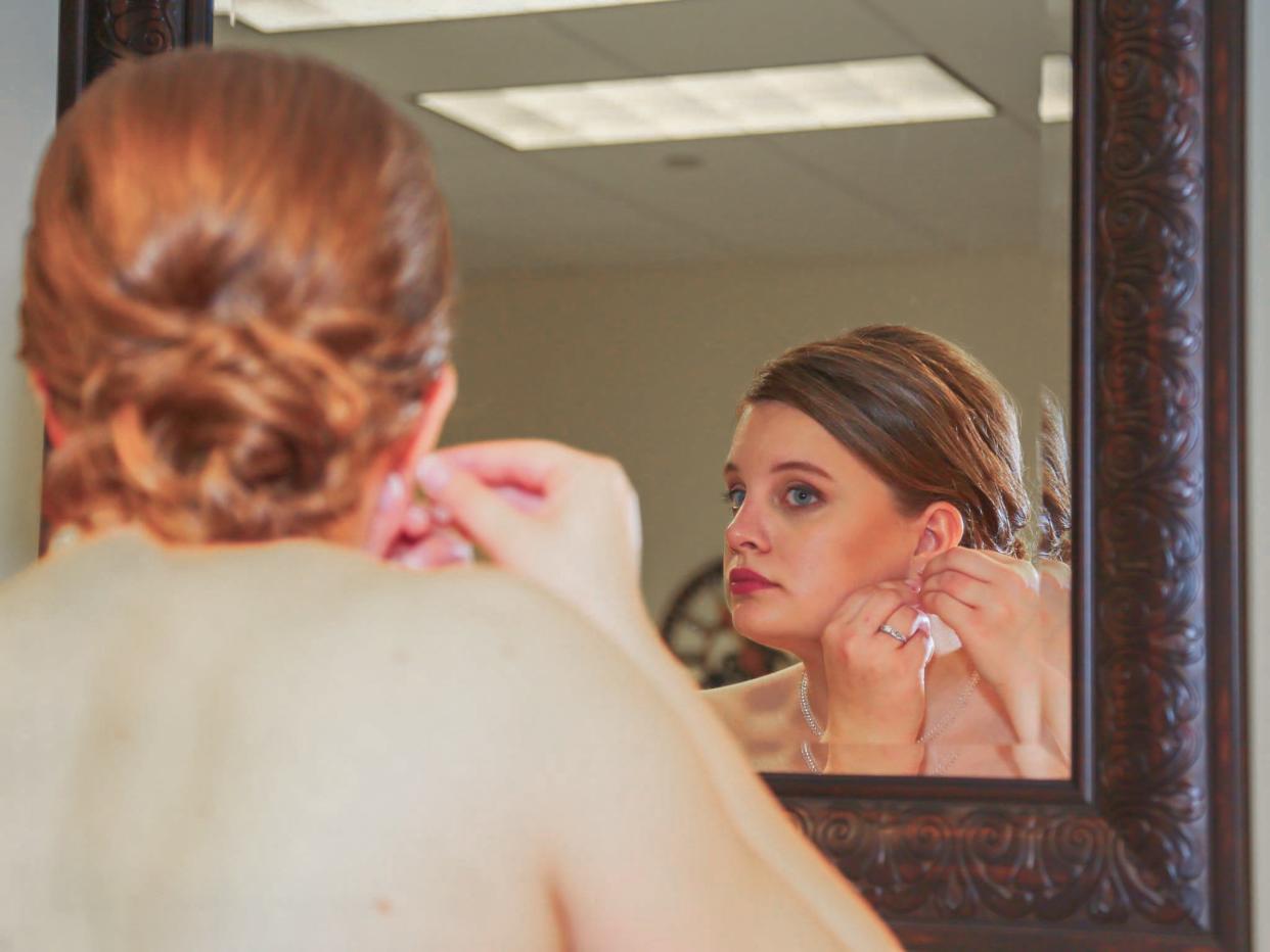 Bride putting on earings