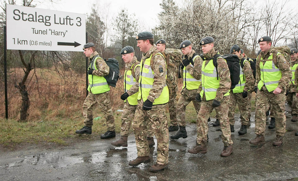 A group of 50 British air force officers are marching from the site of the Nazi Stalag Luft III prisoner camp near Zagan, Poland, on Tuesday, March 25, 2014, to a British war cemetery in western Poland to mark 70 years since the Great Escape of Allied airmen and to honor 50 of them who were caught and executed. They started in rain from the place where 76 prisoners of war emerged from a tunnel on March 24 and 25, 1944. Only three airmen made it home. Fifty others were executed when caught, and 23 were sent to other camps, but survived the war. The 1963 Hollywood movie "The Great Escape," starring Steve McQueen, tells the story. (AP Photo) POLAND OUT