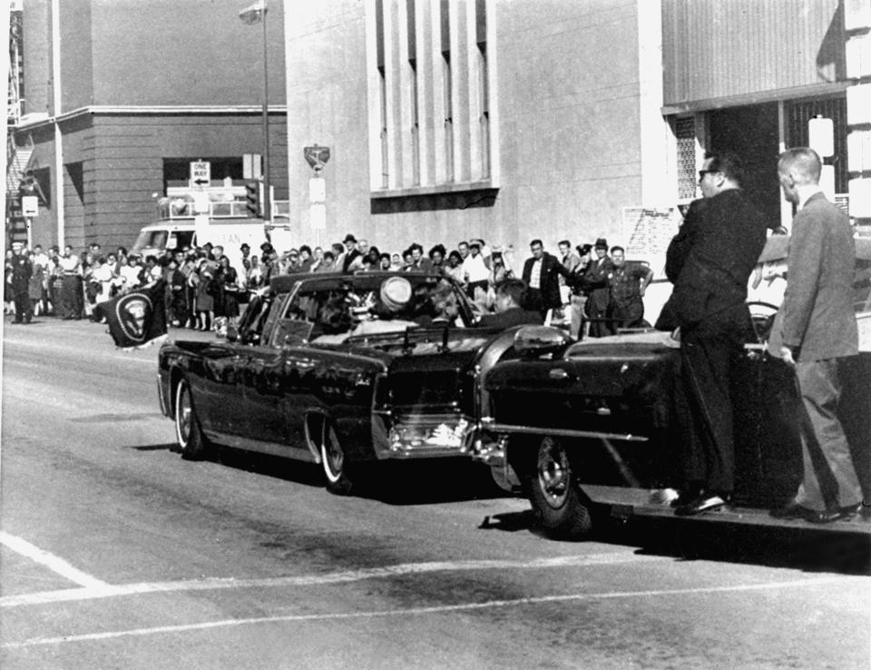 Secret servicemen standing on running boards follow the presidential limousine carrying President John F. Kennedy, right, rear seat, and first lady Jacqueline Kennedy, left, as well as Texas Gov. John Connally and his wife, Nellie, in Dallas, Texas, Nov. 22, 1963. Moments later, President John F. Kennedy was shot by an assassin. (Photo: Jim Altgens/AP)