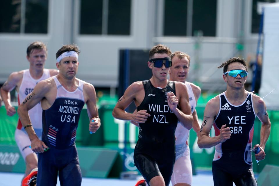 American Kevin McDowell, left, runs in the men's individual triathlon.