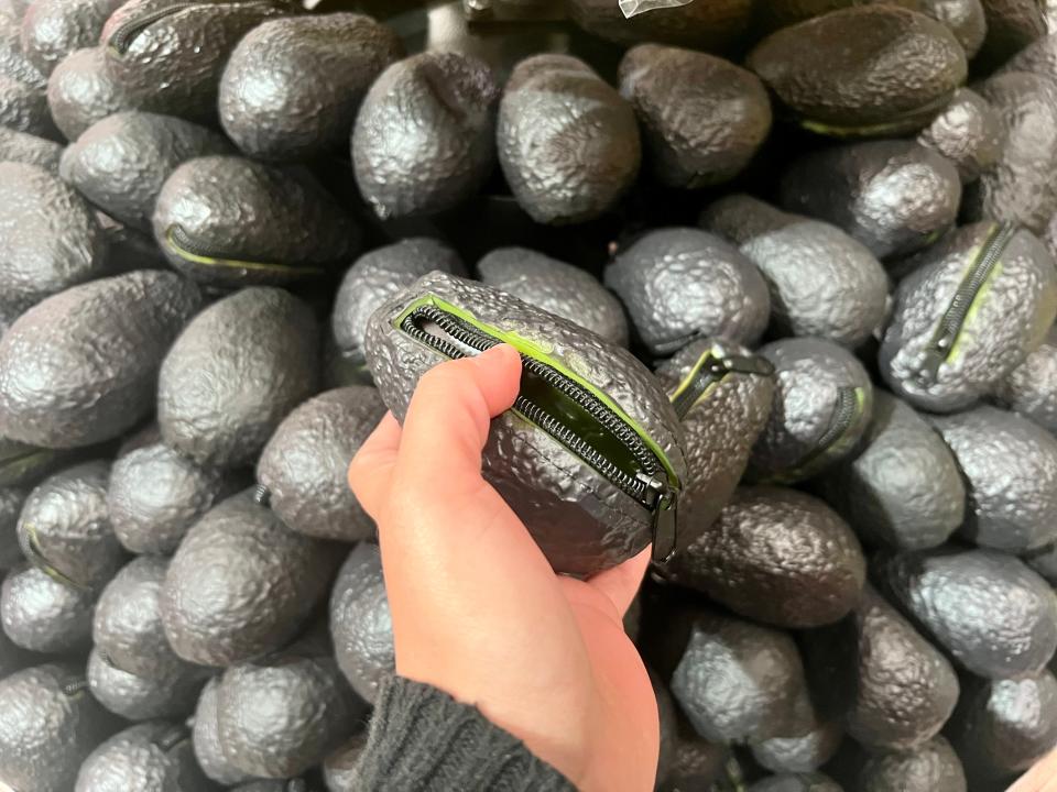 The author holding the avocado coin purse with the zipper open.