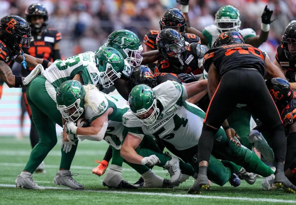 Saskatchewan Roughriders' AJ Ouellette, front left, scores his second touchdown against the B.C. Lions during the second half of a CFL football game, in Vancouver, B.C., Saturday, July 13, 2024.