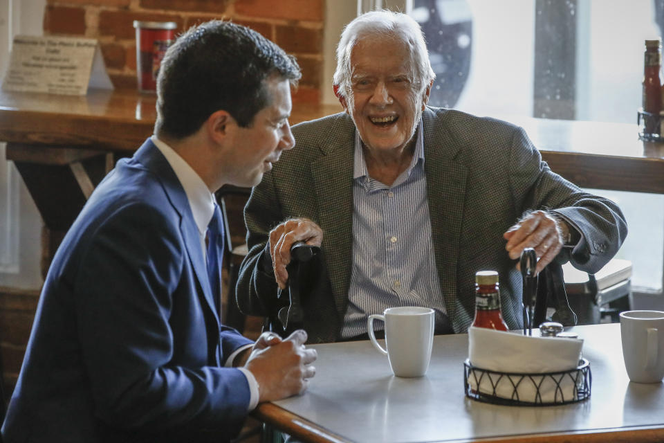 Democratic presidential candidate former South Bend, Ind., Mayor Pete Buttigieg, left, meets with former President Jimmy Carter, center, at Buffalo Cafe in Plains, Ga., Sunday, March 1, 2020. (AP Photo/Matt Rourke)