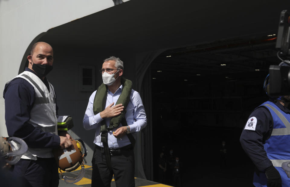 NATO Secretary General Jens Stoltenberg, center, arrives on board the aircraft carrier HMS Queen Elizabeth as it participates in the NATO Steadfast Defender 2021 exercise off the coast of Portugal, Thursday, May 27, 2021. NATO has helped provide security in Afghanistan for almost two decades but the government and armed forces in the conflict-torn country are strong enough to stand on their own feet without international troops to back them, the head of the military organization said Thursday. (AP Photo/Ana Brigida)
