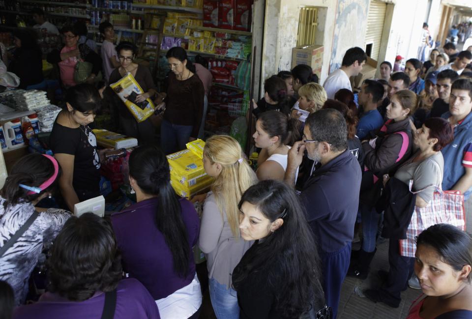 In this June 1, 2013 photo, Paraguayan shoppers buy products in a shop in the town of Clorinda, Argentina, just across the border from Paraguay. Shoppers who turn to the street rather than the banks to swap their dollars are getting a bonanza of extra Argentine pesos and can shop much more cheaply than back at home due to Argentina's currency controls and black market for US dollars. Taking advantage of the guarani’s newfound strength, Paraguayans are rolling by the thousands into the Argentine frontier city of Clorinda to do their shopping. (AP Photo/Jorge Saenz)