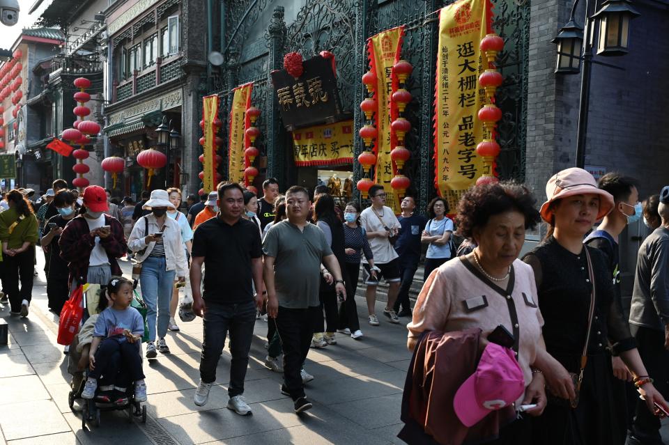 People walk through a traditional shopping street in the Qianmen area of Beijing on May 3, 2023. (Greg baker/AFP via Getty Images)