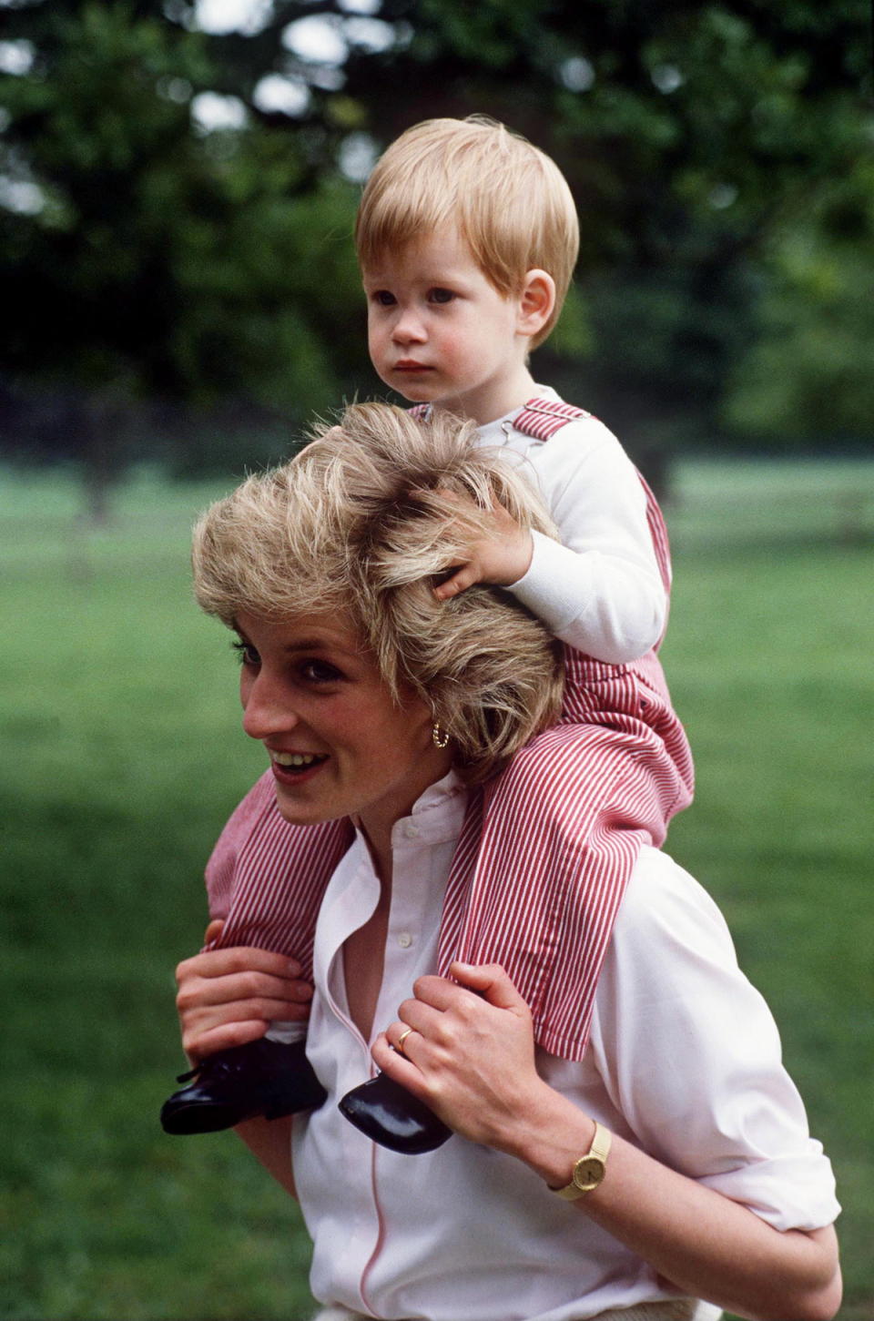 <p>Diana’s short, textured style was already iconic here, when she carried young Harry on her shoulders in a casual moment. (Photo: Tim Graham/Getty Images) </p>