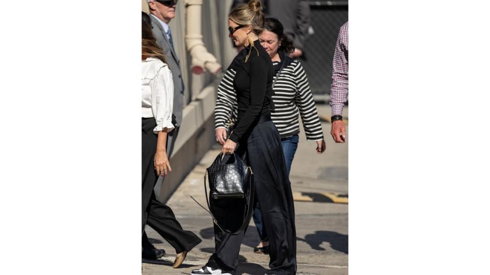 Emily Blunt wearing black turtleneck, croc-effect bag and Nike Dunks 