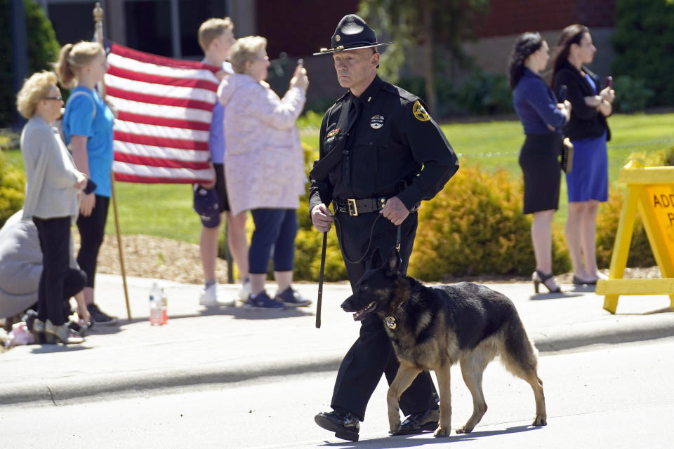 A K-9 officer leads a processional to the Holmes Convocational Center for the funeral services of Watauga County Sheriff's Deputies Sgt. Chris Ward and K-9 Deputy Logan Fox in Boone, N.C., Thursday, May 6, 2021. The two deputies were killed in the line of duty. (AP Photo/Gerry Broome)