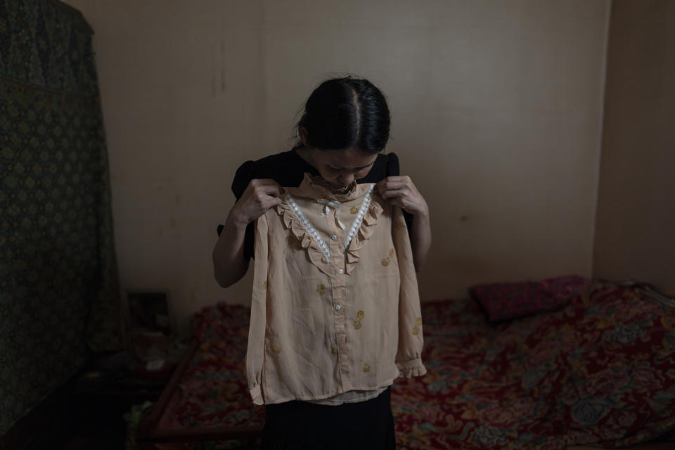 Yooree Kim holds up a blouse given to her by the adoption agency that sent her to France when she was 11 years old, at her apartment in Seoul, South Korea, Saturday, May 18, 2024. (AP Photo/Jae C. Hong)