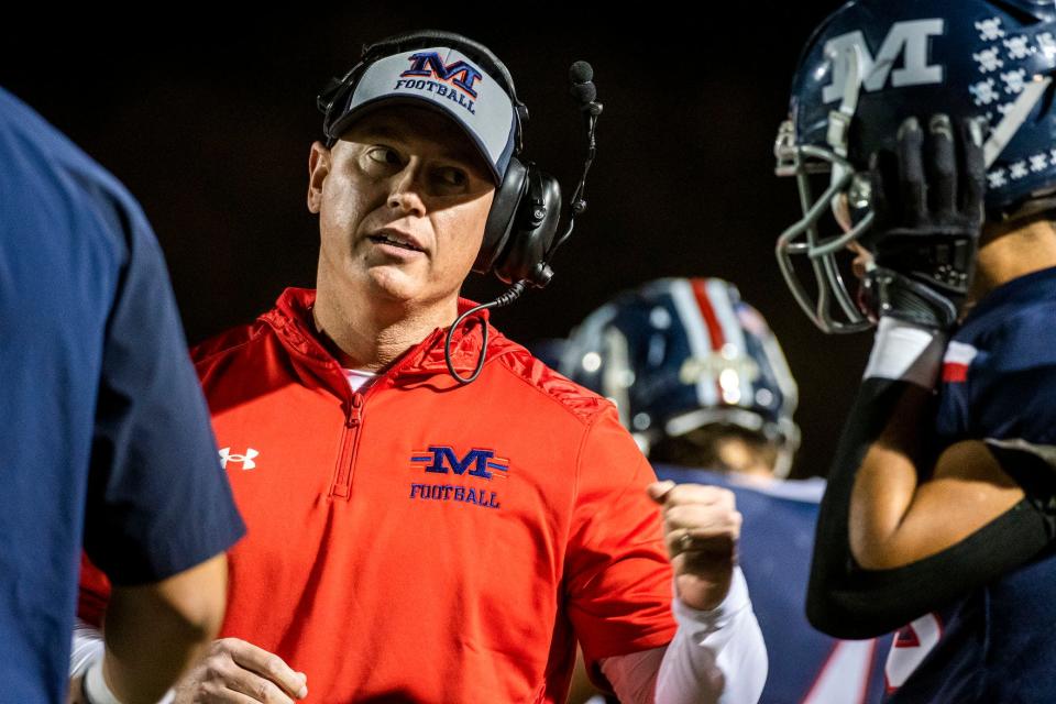 Manhattan High defensive coordinator Adam O'Neill talks to a player on the sidelines during a game in Kansas. O'Neill, a former Peoria High assistant, was hired in February 2023 as head coach at Morton.