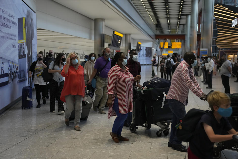 Passengers arrive at Terminal 5 of Heathrow Airport in London, Monday, Aug. 2, 2021. Travelers fully vaccinated against coronavirus from the United States and much of Europe were able to enter Britain without quarantining starting today, a move welcomed by Britain's ailing travel industry. (AP Photo/Matt Dunham)